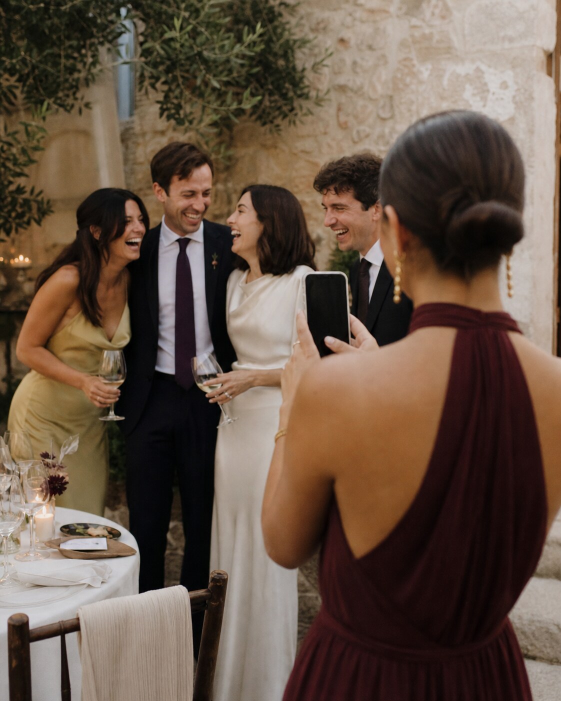 A wedding guest takes a candid photograph of friends celebrating