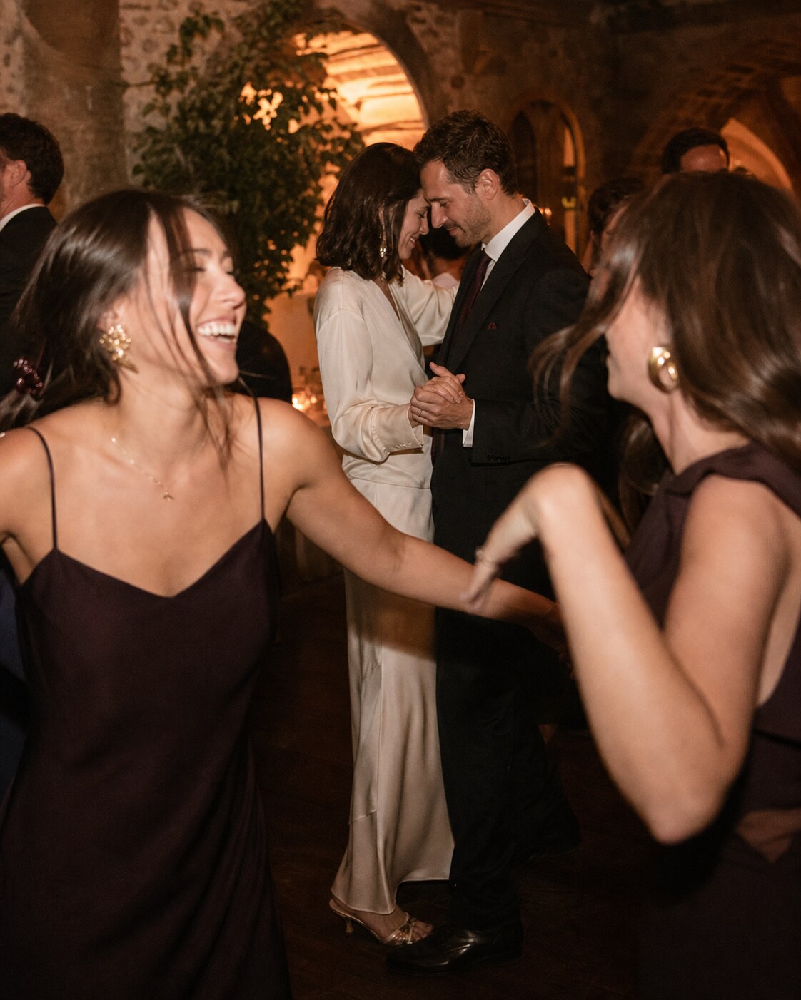 Friends laugh and dance together at the reception